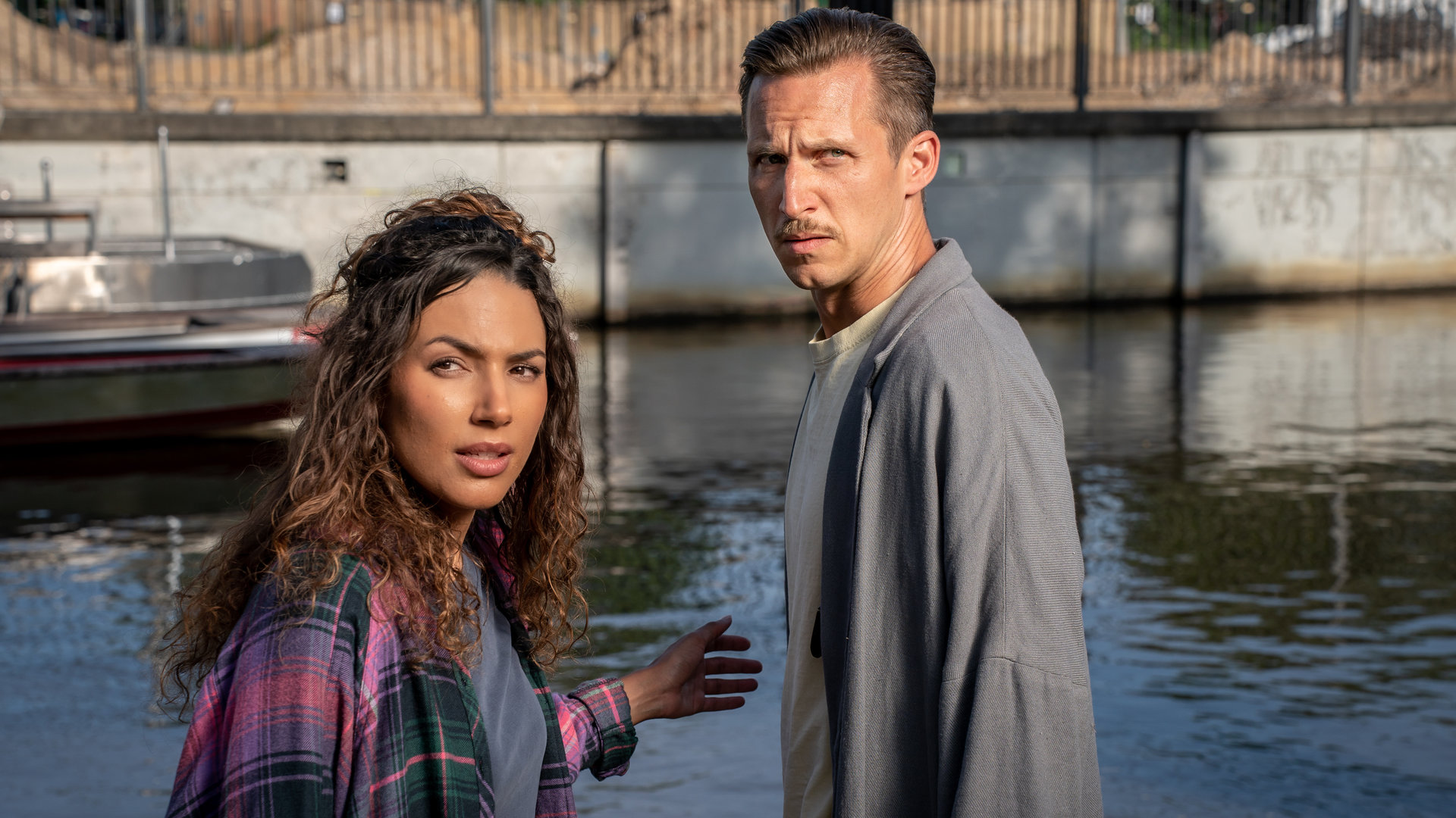 "SOKO Leipzig - Ménage-à-trois": Kim Nowak (Amy Mußul) steht mit Moritz Brenner (Johannes Hendrik Langer) vor einem Kanal. Beide blicken in Richtung Kamera.