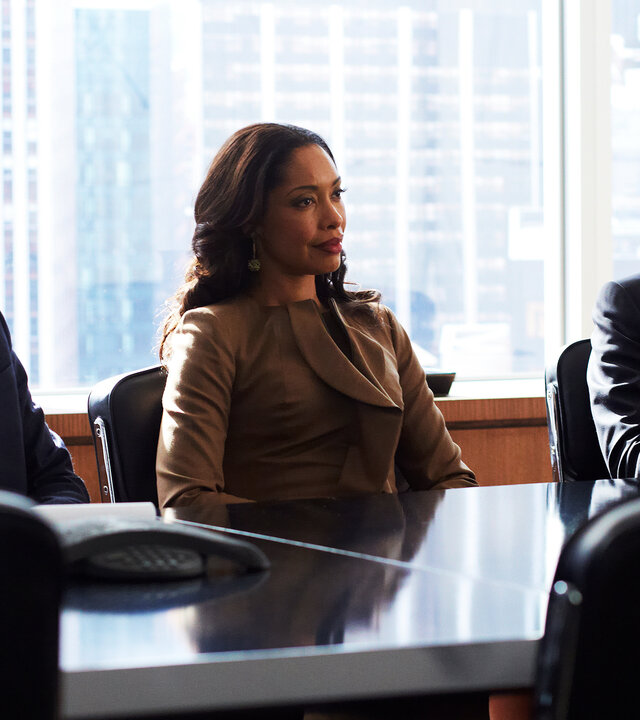 "Suits - Alte Feinde": Mike (Patrick J. Adams), Jessica (Gina Torres) und Harvey (Gabriel Macht) sitzen nebeneinander an einem Konferenztisch. Alle drei blicken angespannt in dieselbe Richtung. Hinter ihnen ist die Skyline New Yorks zu sehen.