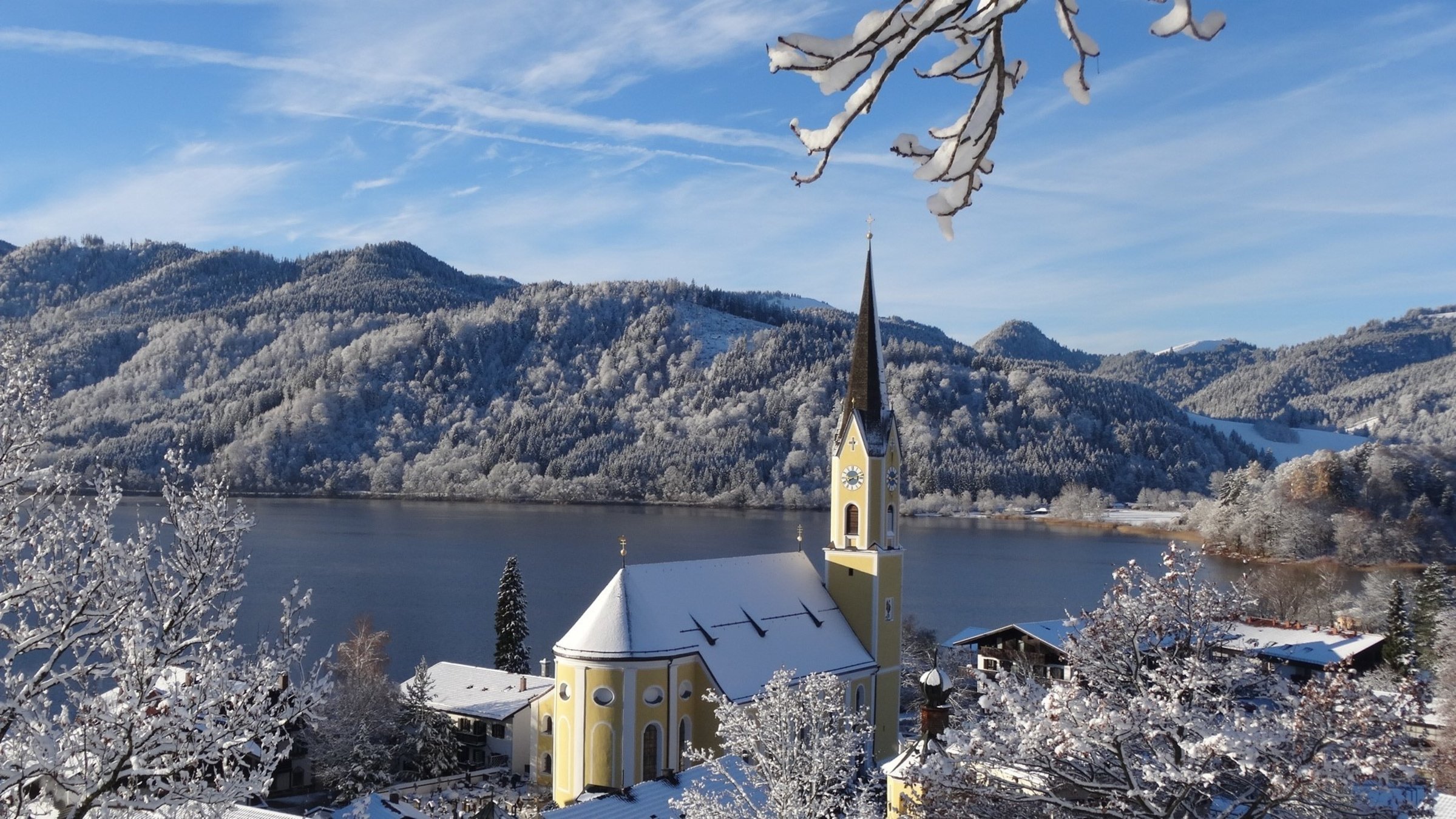"Weihnachtssingen in Schliersee": Die Pfarrkirche St. Sixtus in Schliersee in verschneiter Winterlandschaft.