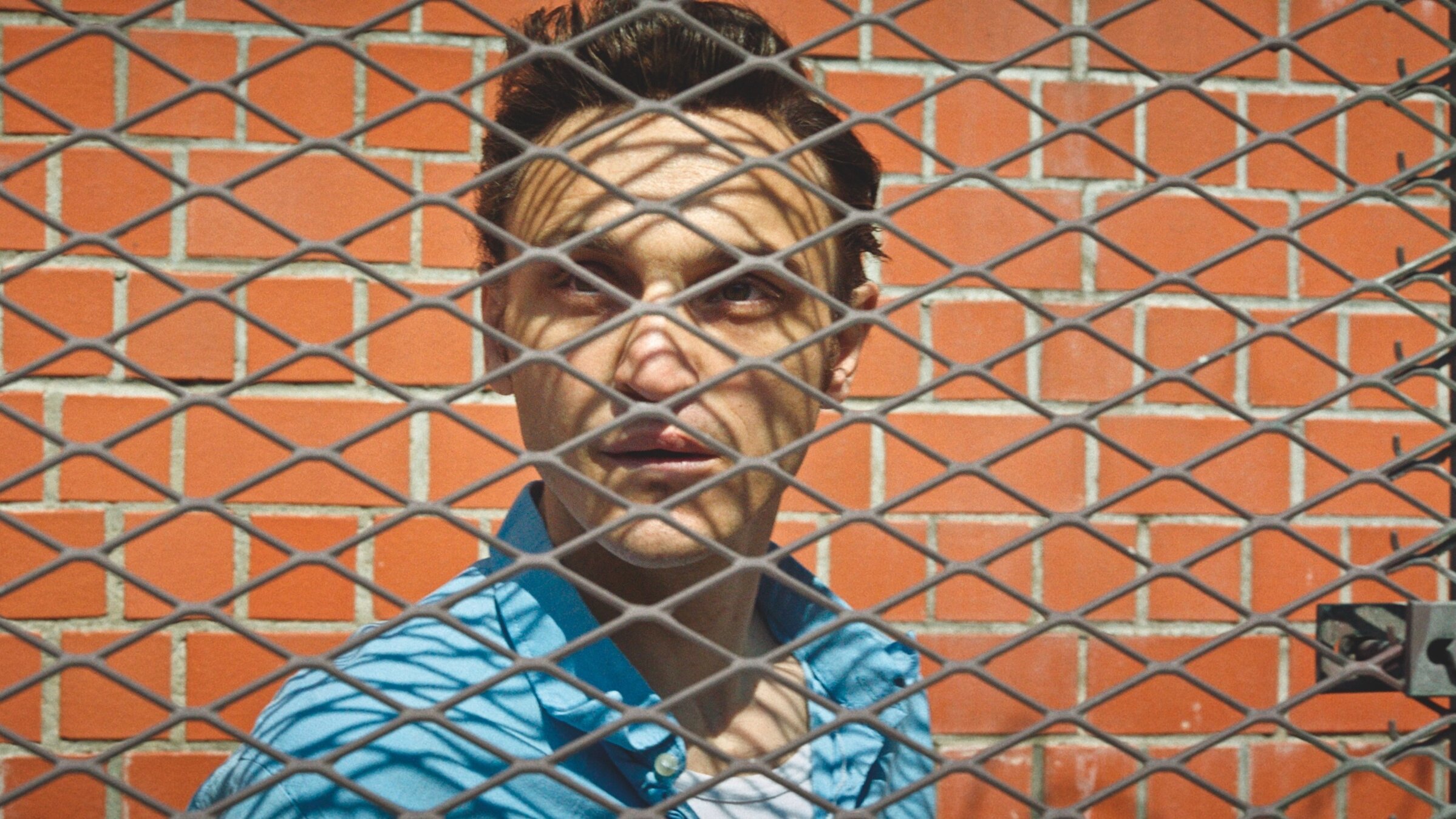 "Große Freiheit": Nahaufnahme von Hans Hoffmann (Franz Rogowski) hinter dem dicken Draht eines Zaunes.