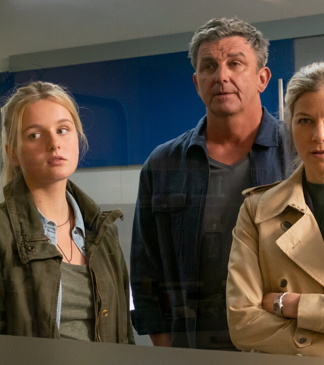"Der Bergdoktor - Paradies (2)": Martin (Hans Sigl), Josie (Lieselotte Voß) und Karin Bachmeier (Hilde Dalik) stehen nebeneinander im Krankenhaus und blicken durch ein Fenster geradeaus.