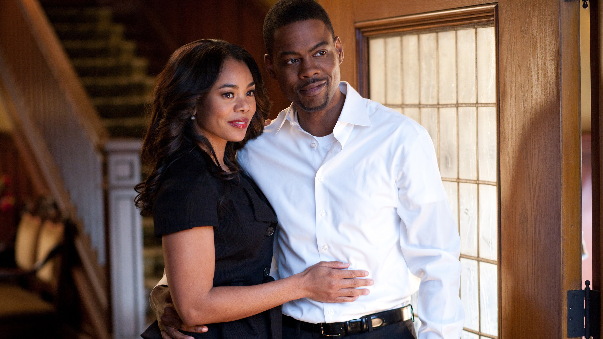 "Sterben will gelernt sein": Aaron (Chris Rock) steht in seinem Wohnzimmer und hält seine Frau Michelle (Regina Hall) im Arm, die neben ihm steht.