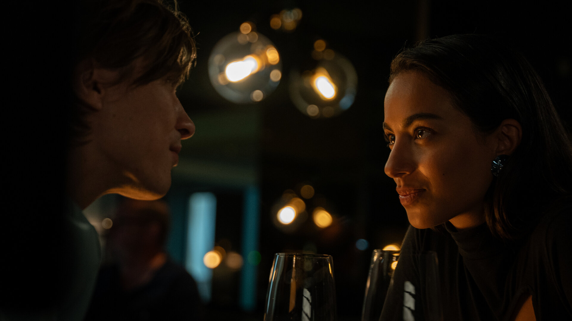 "Crystal Wall - Eifersucht": Dita (Gizem Emre) und Nicolas Dardenne (Gustav Schmidt) sitzen sich in einem abgedunkeltem Restaurant gegenüber und schauen sich tief in die Augen.