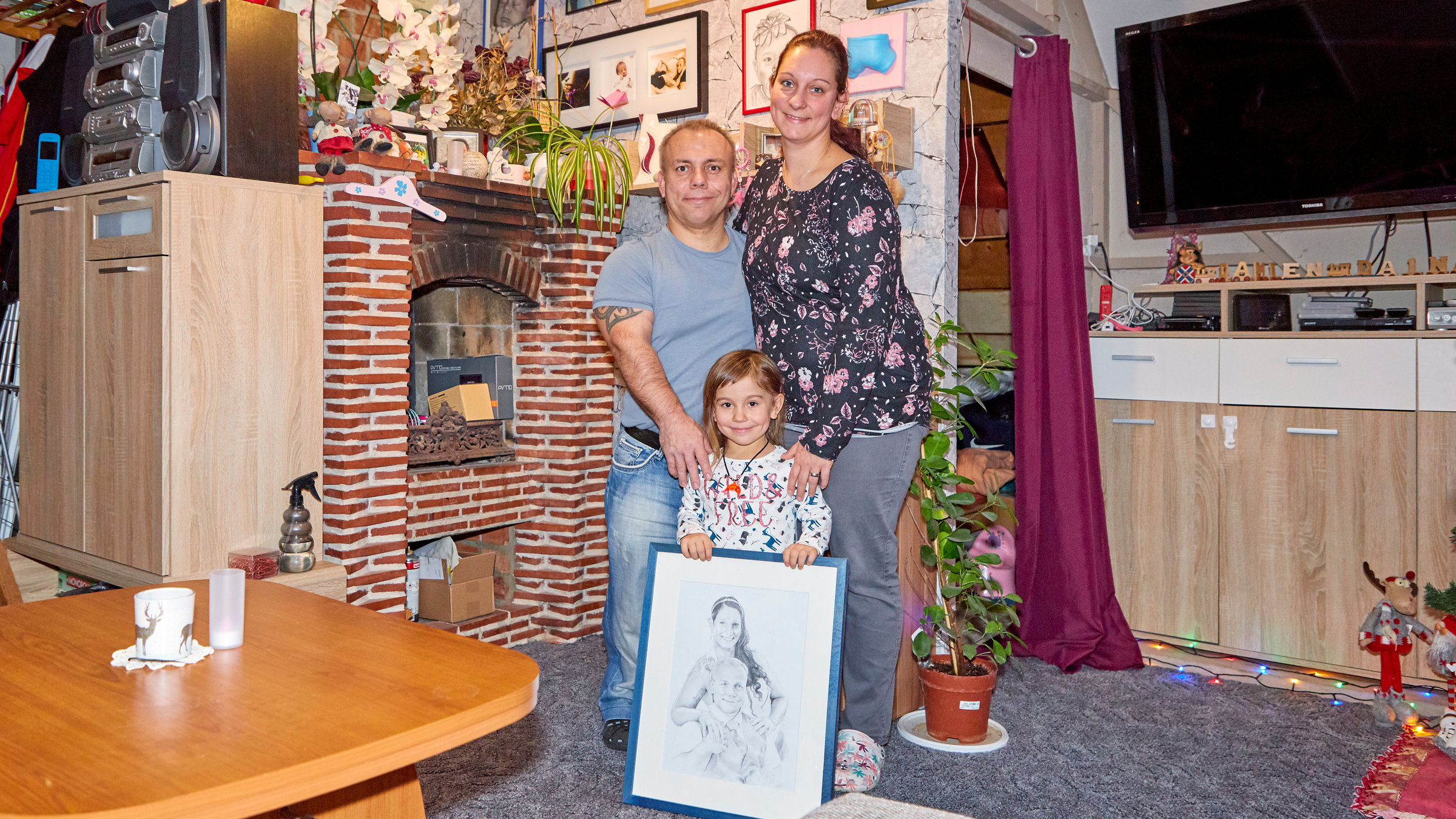 "37°: Nie auf Augenhöhe - Von kleinen und großen Menschen": Der kleinwüchsige Ralf und seine normal gewachsene Frau stehen mit ihrer kleinen Tochter Judy in ihrem Wohnzimmer.