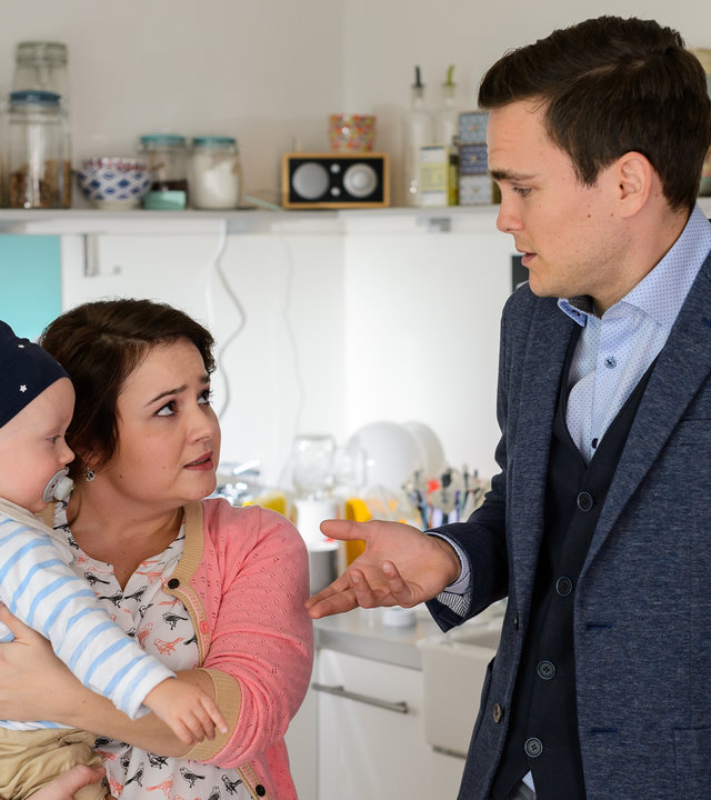"Bettys Diagnose - Alles Fake!": Talula Pfeifer (Carolin Walter) hält ihr Baby Emil (Komparse) auf ihren Armen, während Tobias Lewandowski (Eric Klotzsch) sie fragend anschaut.