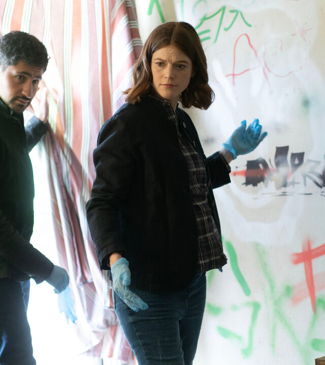 "Vigil - Tödliche Drohnen: Wüstenstaat": Kirsten Longacre (Rose Leslie) und ihr Kollege Daniel Ramsay (Amir El-Masry) stehen in einer Wohnung vor einen bekritzelten Wand und schauen sich um.