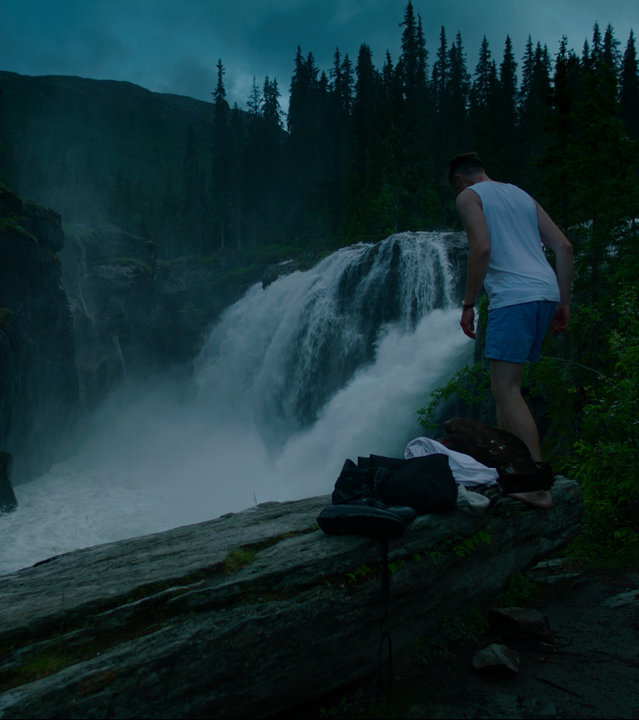 "Exit - Abgesang": William (Pål Sverre Hagen) steht in Unterwäsche auf einer Klippe vor einem Wasserfall und schaut nach unten.