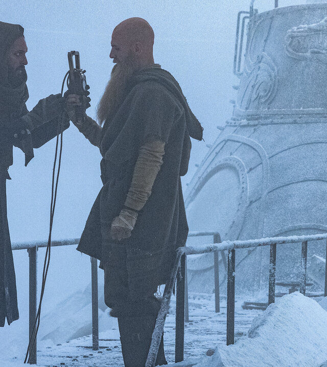 "Nautilus - Gefangen im Eis": Nemo (Shazad Latif) und Jiacomo (Andrew Shaw) stehen sich auf dem vereisten U-Boot Nautilus gegenüber. Nemo übergibt Jiacomo einen Gegenstand, an dem ein langes Kabel befestigt ist.