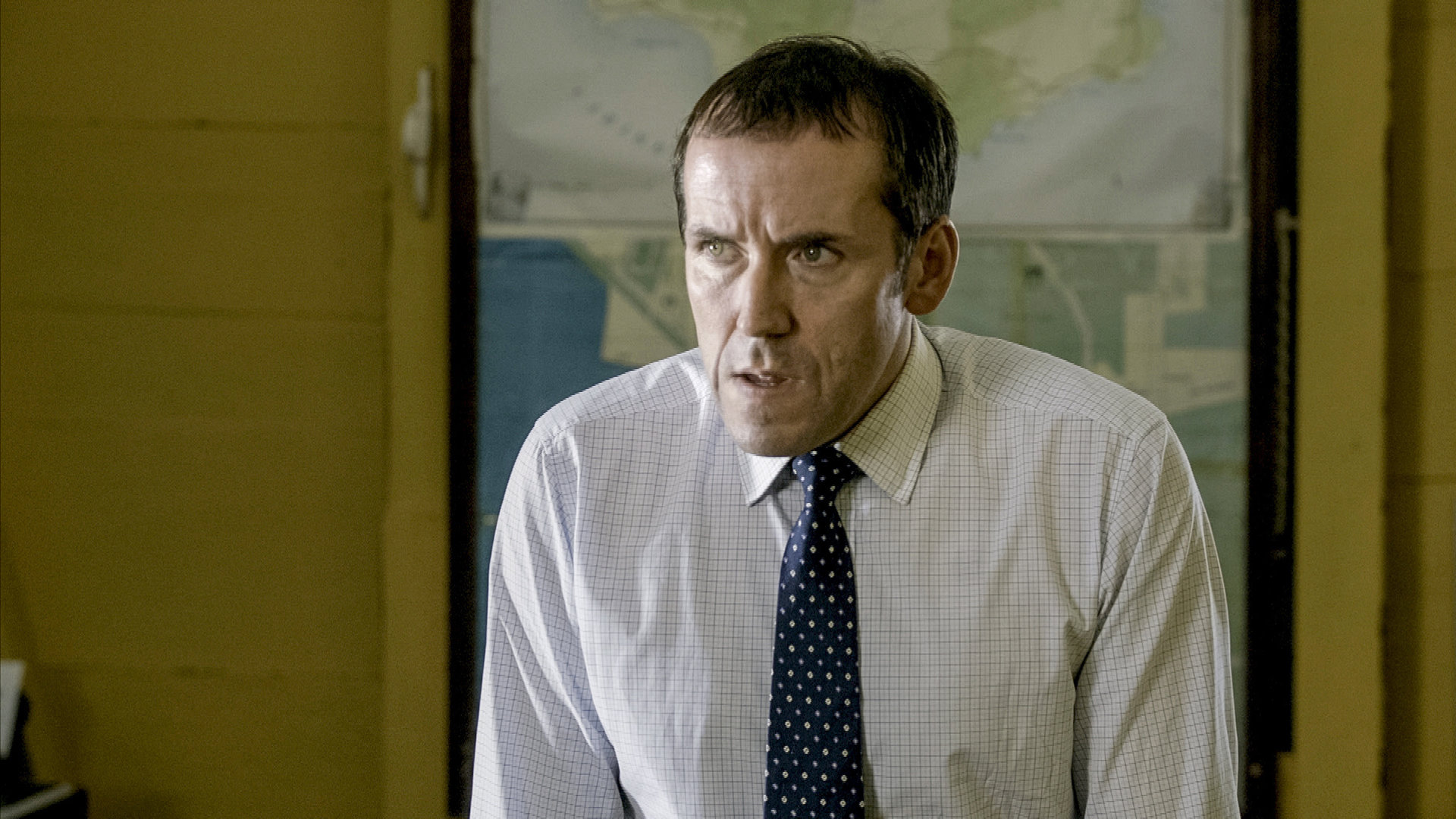 "Death in Paradise - Das Auge des Hurrikans": DI Richard Poole (Ben Miller) stützt sich auf beiden Armen ab und guckt fragend zur Seite.
