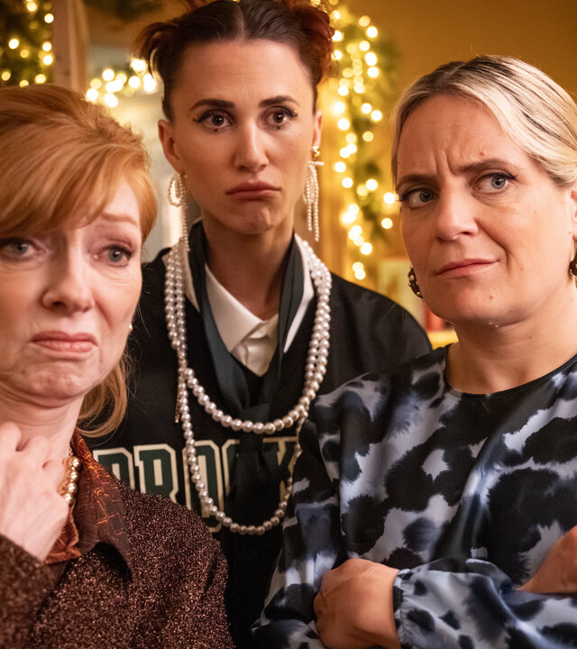 "Single Bells - Only Losers for Annie? - Damien (I)": Annie (Marleen Merckx), Daffy (Lize Feryn), Babs (Ruth Beeckmans) stehen in einem Raum und schauen sehr skeptisch.
