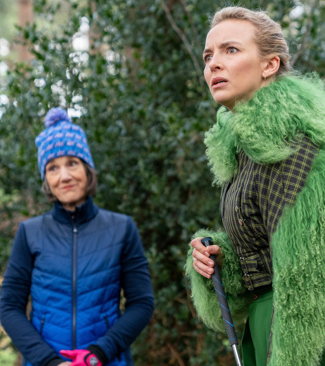 "Killing Eve - Er schreit förmlich danach, umgebracht zu werden": Villanelle (Jodie Comer) und Dasha (Harriet Walter) stehen mit Golfausrüstung in einem Wald und halten nach etwas Ausschau.