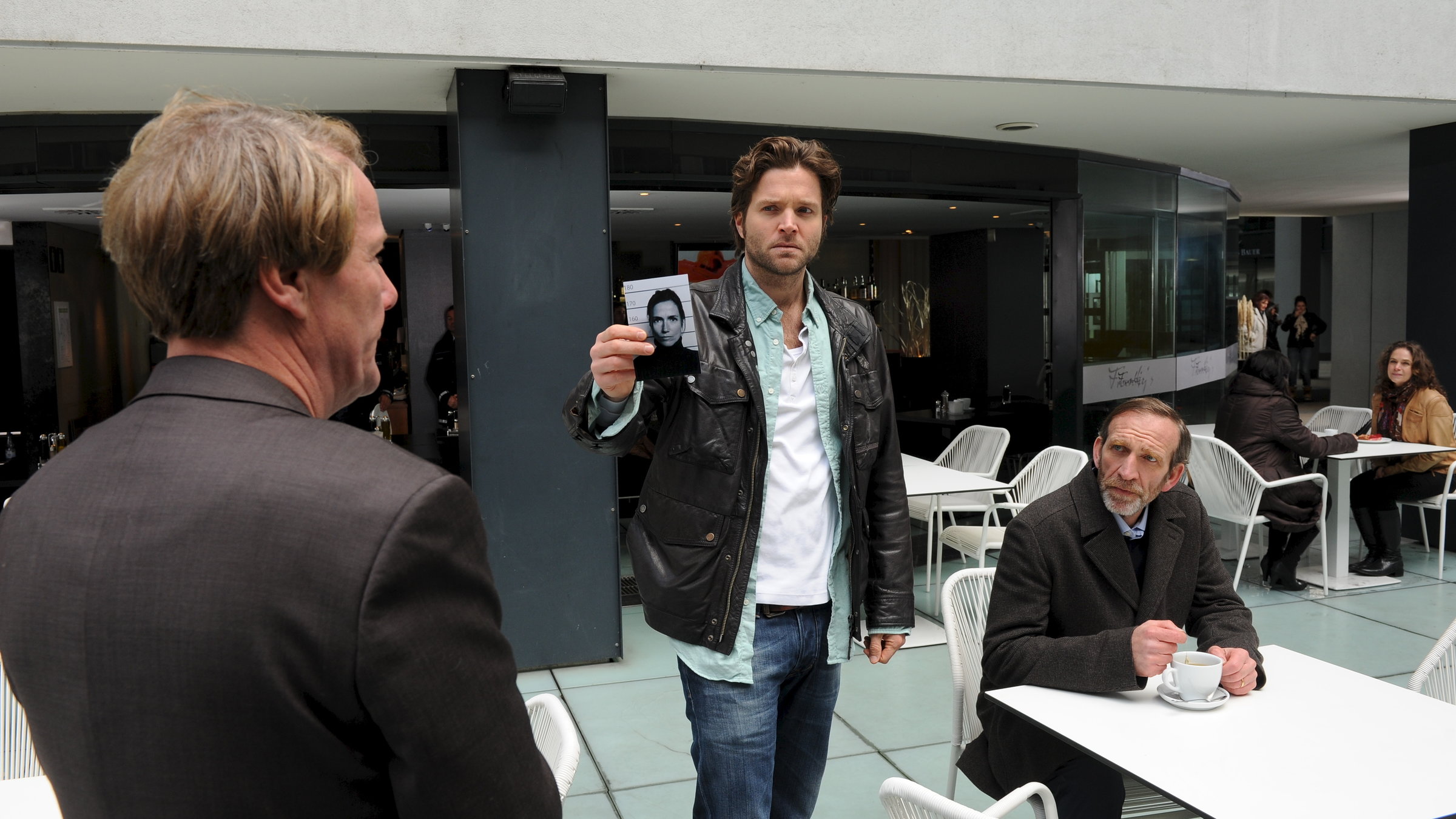 "SOKO Stuttgart - Rache": Jo Stoll (Peter Ketnath) zeigt Frank Habermann (Torsten Ranft) und Jürgen Sessler (Jochen Nickel) ein Bild. Sie befinden sich in einer Cafeteria.