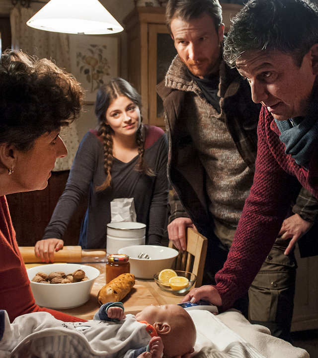 "Der Bergdoktor - Wunschkind": Lisbeth (Monika Baumgartner) hat ein Baby vor sich auf dem Tisch liegen und hält es vorsichtig fest. Lilli (Ronja Forcher), Hans (Heiko Ruprecht) und Martin (Hans Sigl) stehen um den Tisch herum und betrachten beide mit sorgenvollen Gesichtern.
