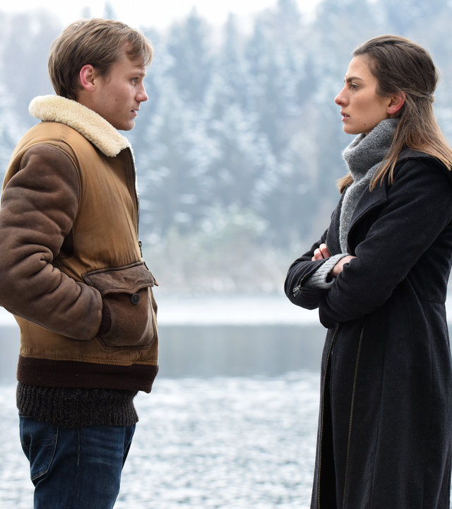 "Winterherz - Tod in einer kalten Nacht ": Mike (Anton Spieker) und Sylvie (Laura de Boer) stehen sich in einer kalten Winterlandschaft gegenüber und schauen sich an. Im Hintergrund ein See.