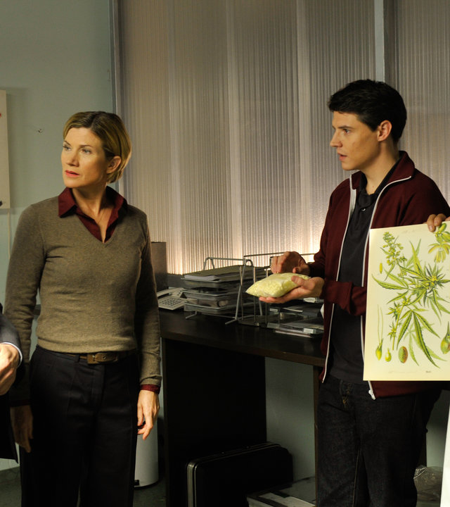 "SOKO Stuttgart - Frauenbier": Kriminaldirektor Michael Kaiser (Karl Kranzkowski) beratschlagt sich mit Martina Seiffert (Astrid M. Fünderich), Rico Sander (Benjamin Strecker) und Jan Arnaud (Mike Zaka Sommerfeldt), der zwei Zeichnungen mit Blättern in die Höhe hält.