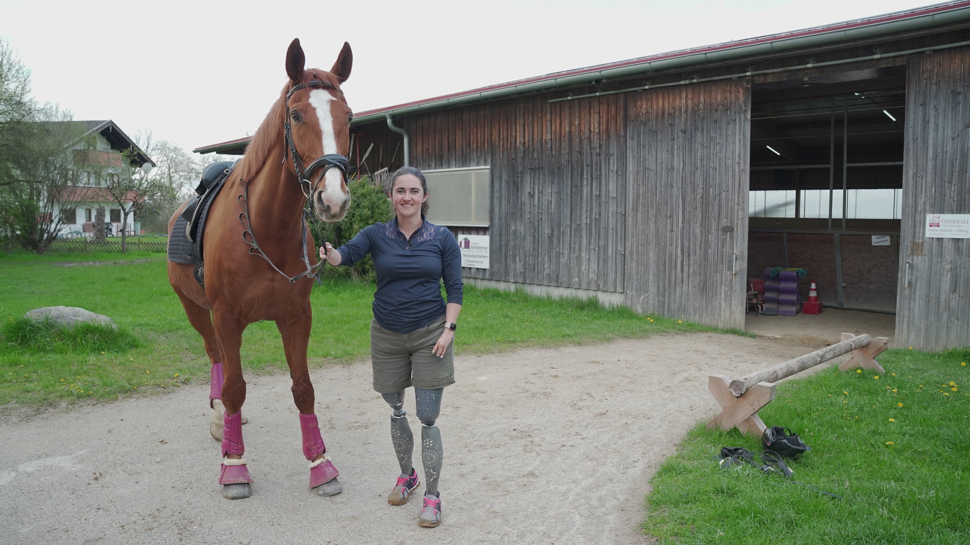 "einfach Mensch - Julia Porzelt: Nicht ohne mein Pferd!": Julia Porzelt steht mit ihrem Pferd Bruno vor einer Reithalle.