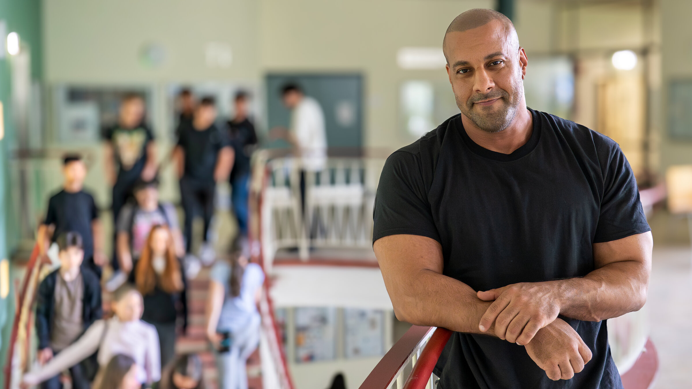 "37° - Ein Lehrer geht viral": Lehrer Reff lehnt am Treppengeländer in seiner Schule. Auf der Treppe sind mehrere Schüler zu sehen.