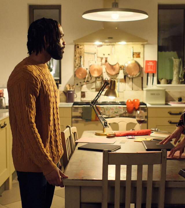 "The Killing Kind: Schatten der Vergangenheit": Ingrid (Emma Appleton) und ihr Verlobter Mark (Elliot Barnes-Worrell) stehen sich in ihrer Küche an ihrem Küchentisch gegenüber. Sie blicken ernst.