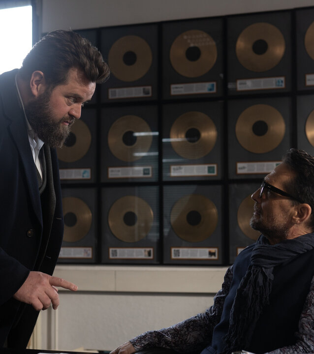 "Ein Fall für zwei - Showbizz": Benjamin Hornberg (Antoine Monot) steht neben Lennart Parker (Robert Seeliger), der im Büro seines Plattenstudios am Schreibtisch sitzt. Benni redet mit ernstem Gesichtsausdruck auf ihn ein.