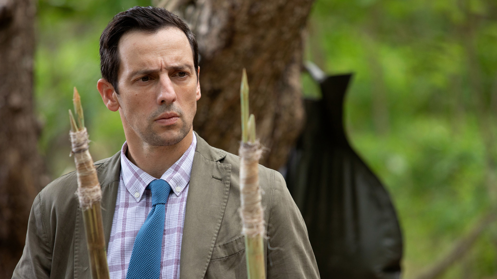 "Death in Paradise - Mosquito Island": Detektive Neville Parker (Ralf Little) schaut konzentriert auf zwei Speere.