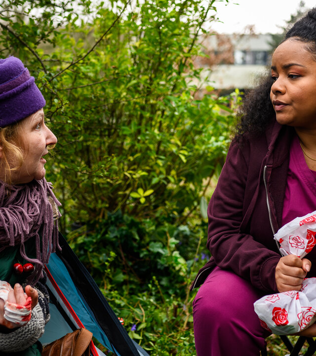 "Bettys Diagnose - Alles verloren": Im Park: Brigitte (Inga Dietrich) schaut aus ihrem Zelt und blickt Zoe (Catherine Chikosi) an, die auf einem Klapphocker daneben sitzt und eine Tüte in den Händen hält.