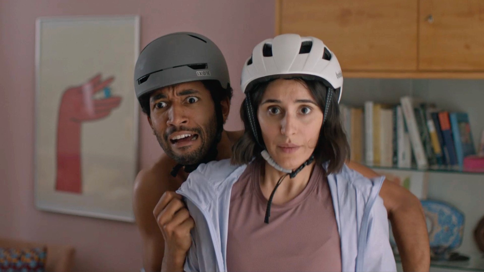 "Doppelhaushälfte": Theo (Benito Bause) versteckt sich erschrocken hinter Mari (Maryam Zaree). Beide tragen in der Wohnung Fahrradhelme.