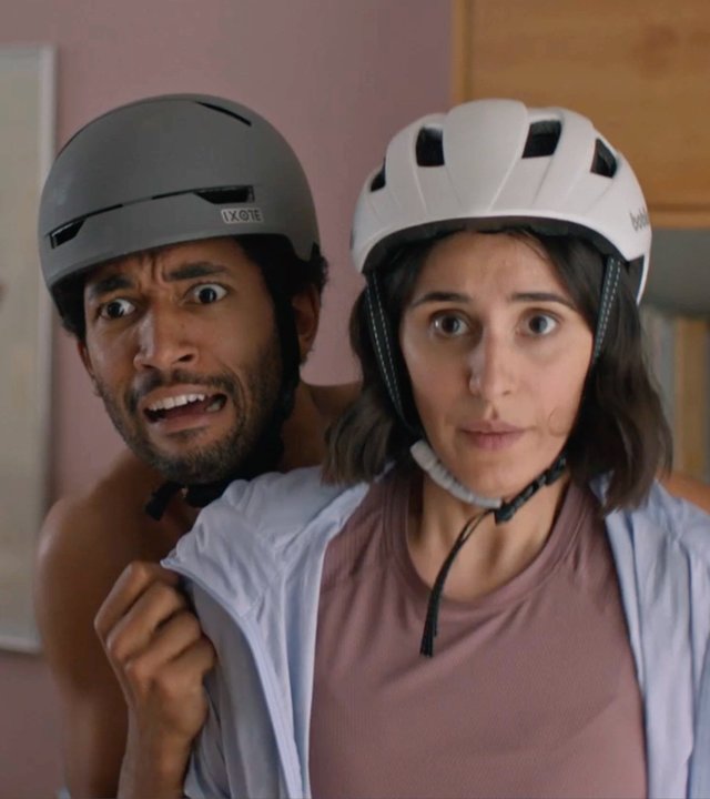 "Doppelhaushälfte": Theo (Benito Bause) versteckt sich erschrocken hinter Mari (Maryam Zaree). Beide tragen in der Wohnung Fahrradhelme.