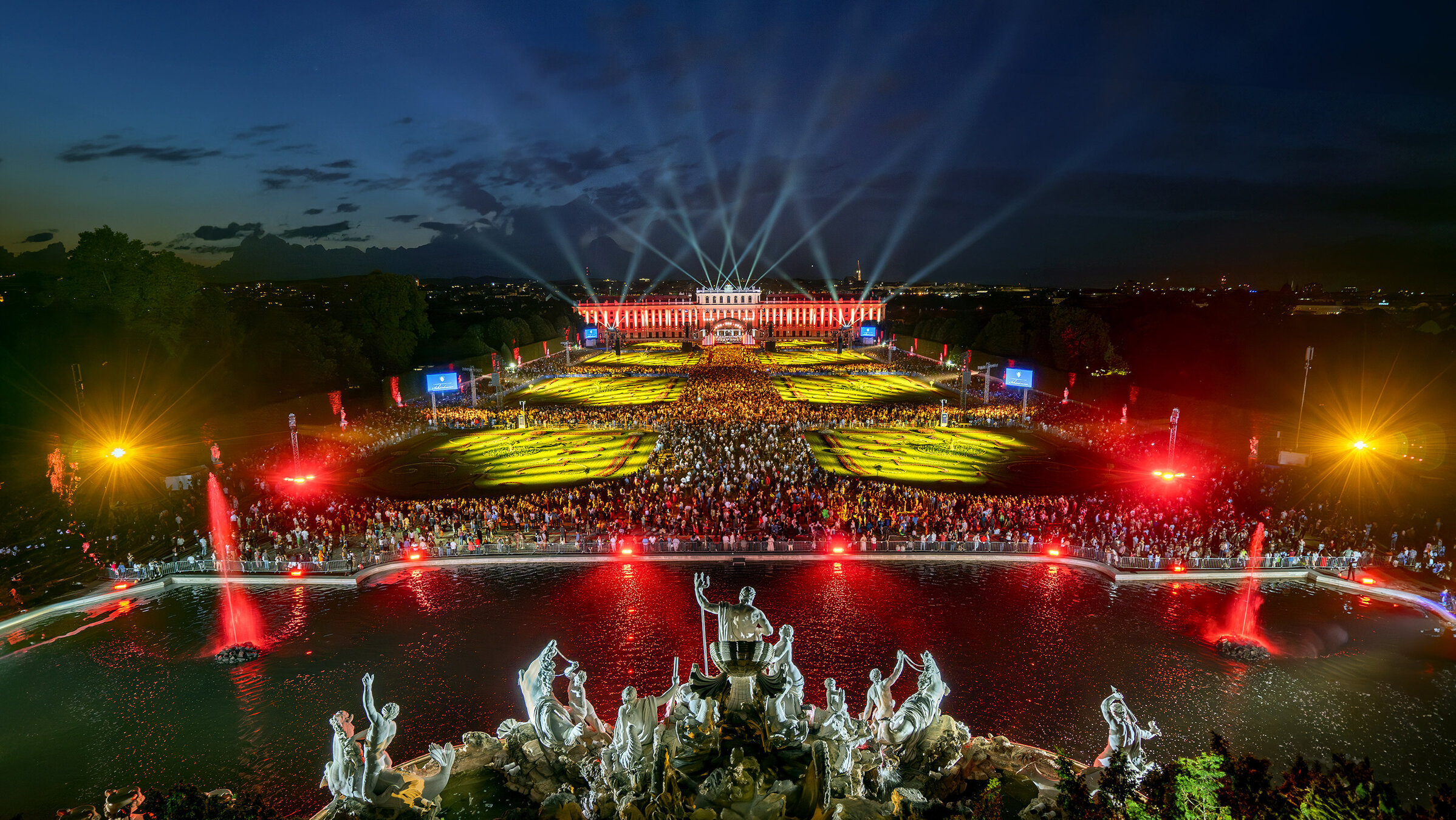 "Sommernachtskonzert Schönbrunn 2025": Schlosspark Schönbrunn bei Nacht, aufwendig illuminiert.