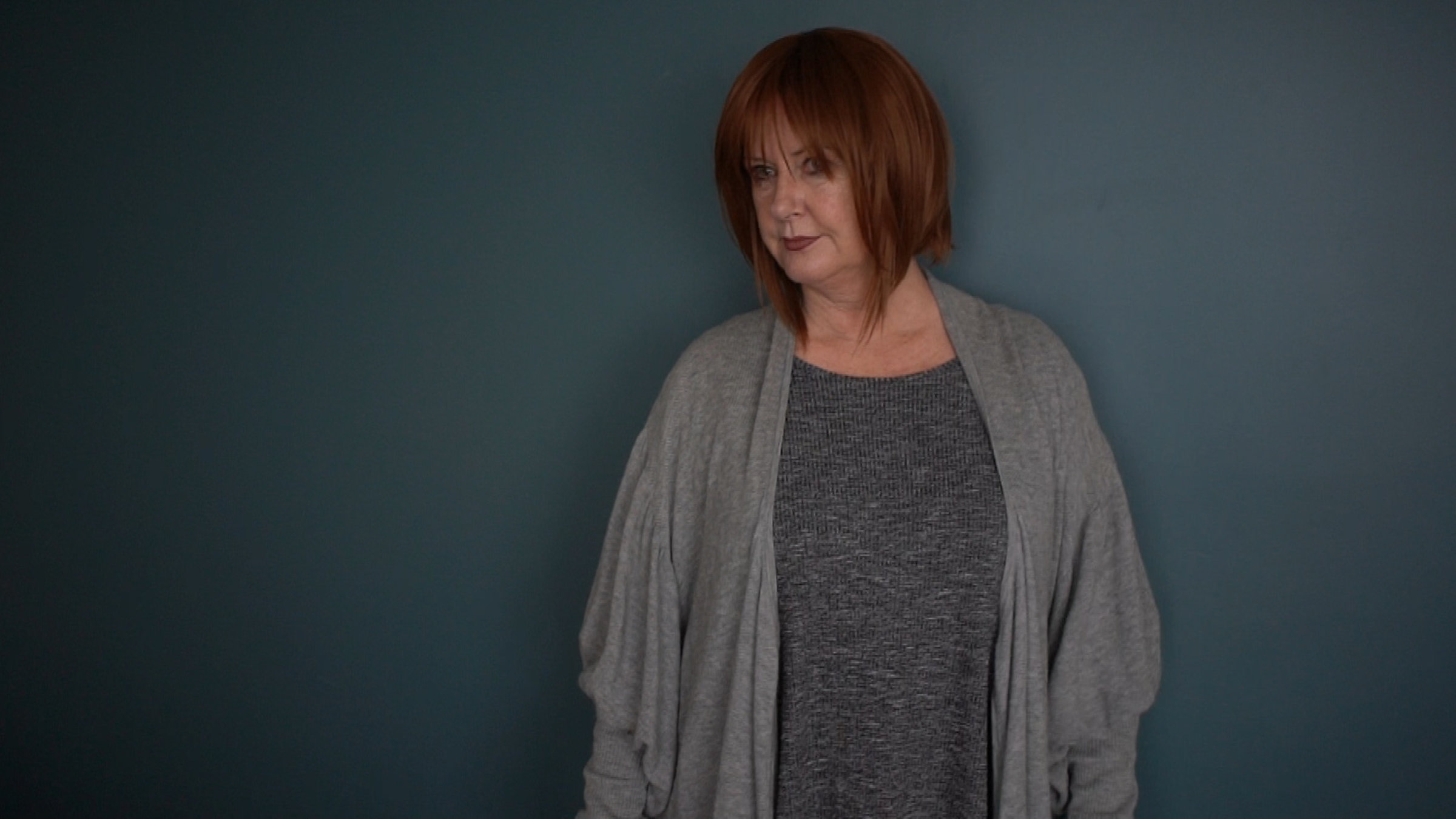 "37°: Mein stiller Freund - Wenn Frauen trinken": Claudia steht vor einer grauen Wand und schaut nachdenklich ins Leere.