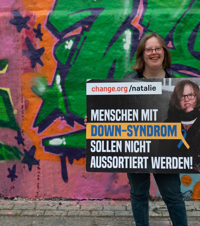 "einfach Mensch: Natalie Dedreux - Trisomie 21, so what!": Natalie Dedreux hält ein Schild auf dem steht, dass Menschen mit Downsyndrom nicht aussortiert werden dürfen.