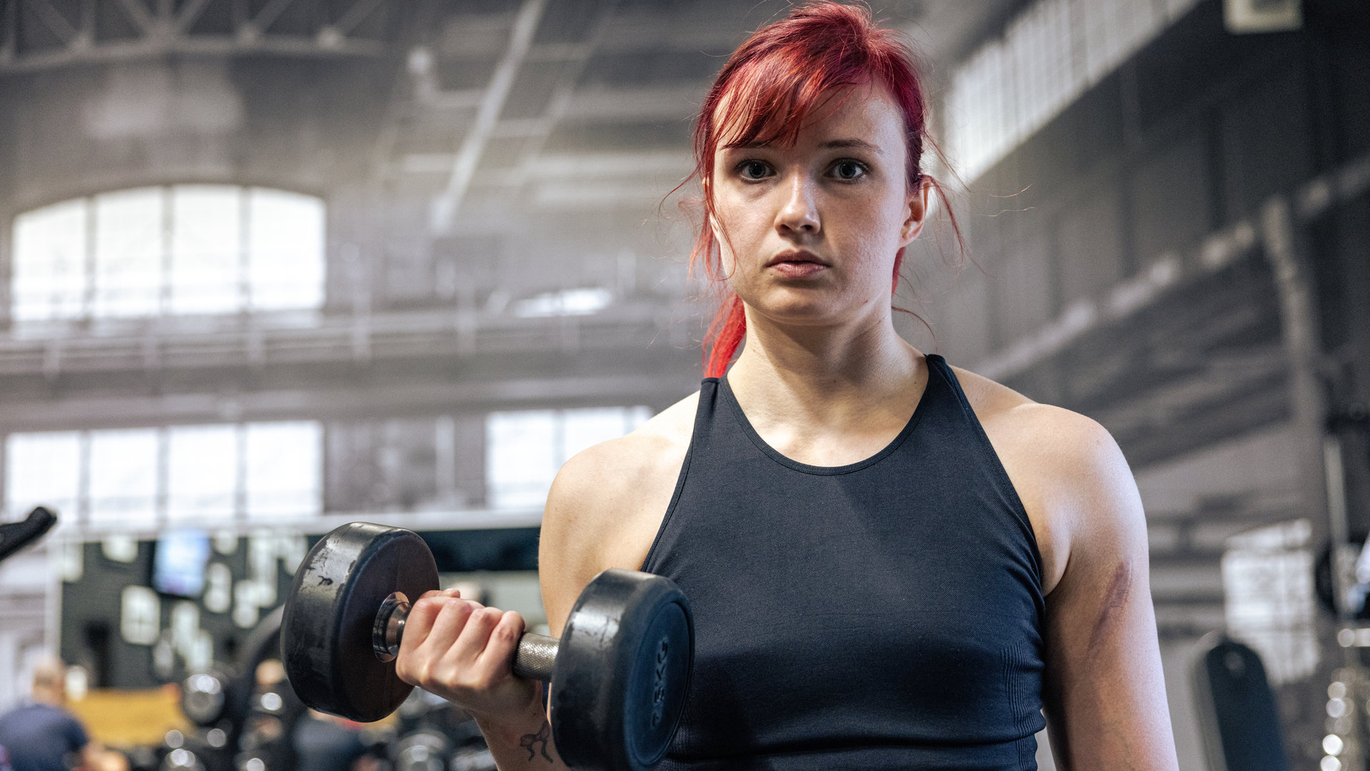 "37°Leben": Farina hebt eine Hantel hoch, steht im Fitnesscenter und schaut in die Kamera.