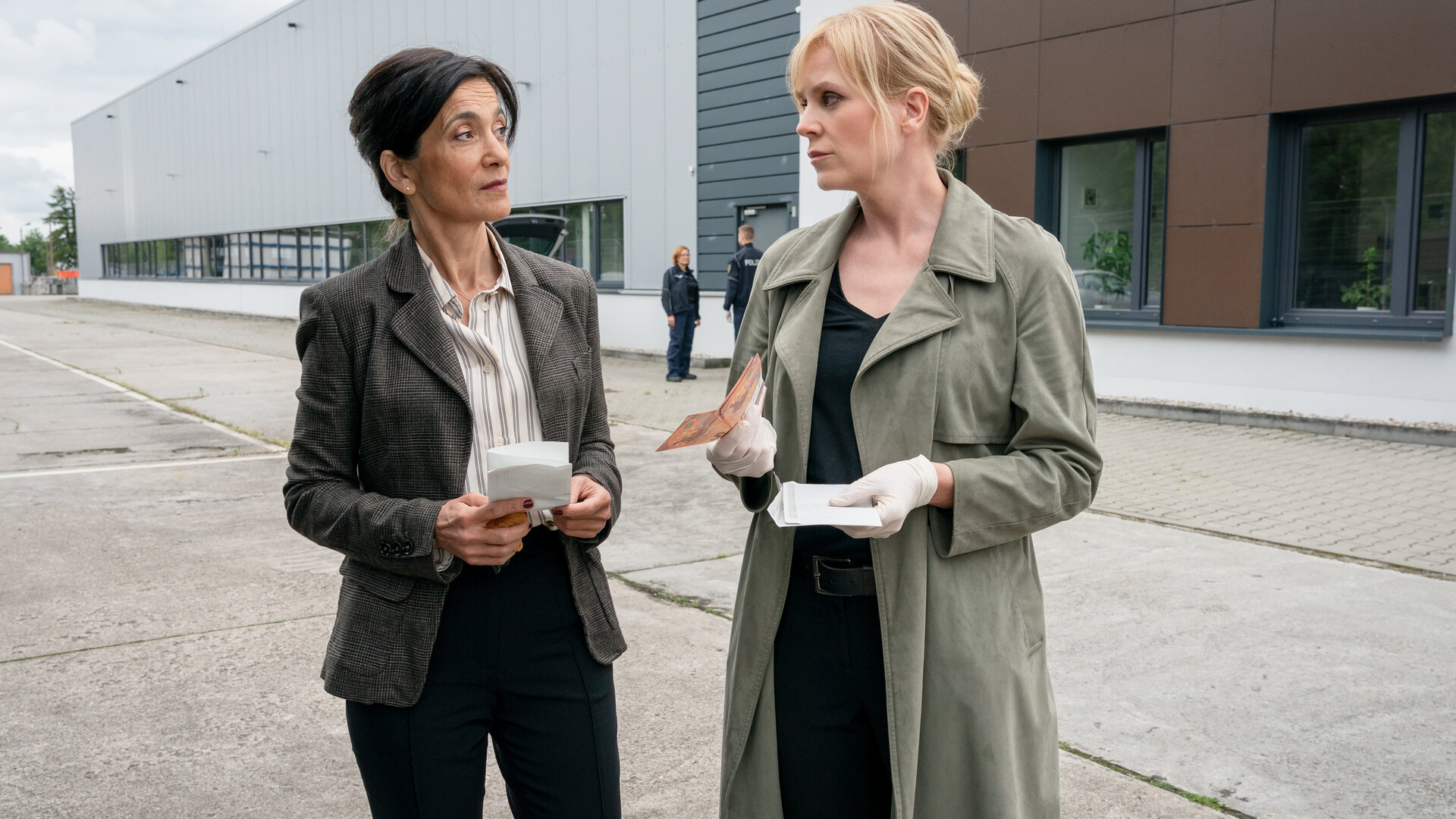 "SOKO Leipzig - Gas, Wasser,  Lügen": Saskia Henze (Berivan Kaya) und Ina (Melanie Marschke) stehen auf einem Parkplatz in einem Industriegebiet. Beide blicken sich skeptisch an.