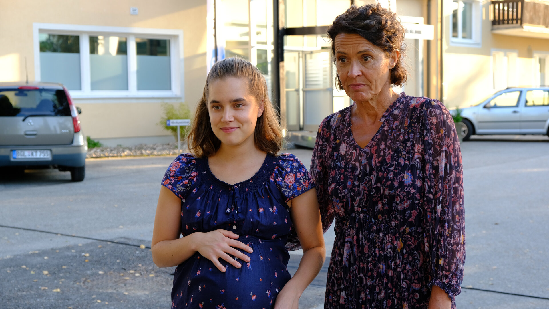 "Lena Lorenz - Baby auf Probe": Vor dem Eingang zum Krankenhaus stehen Regine Moosleitner (Ulrike Folkerts) und ihre hochschwangere Tochter Alina (Anne-Marie Lux) nebeneinander.