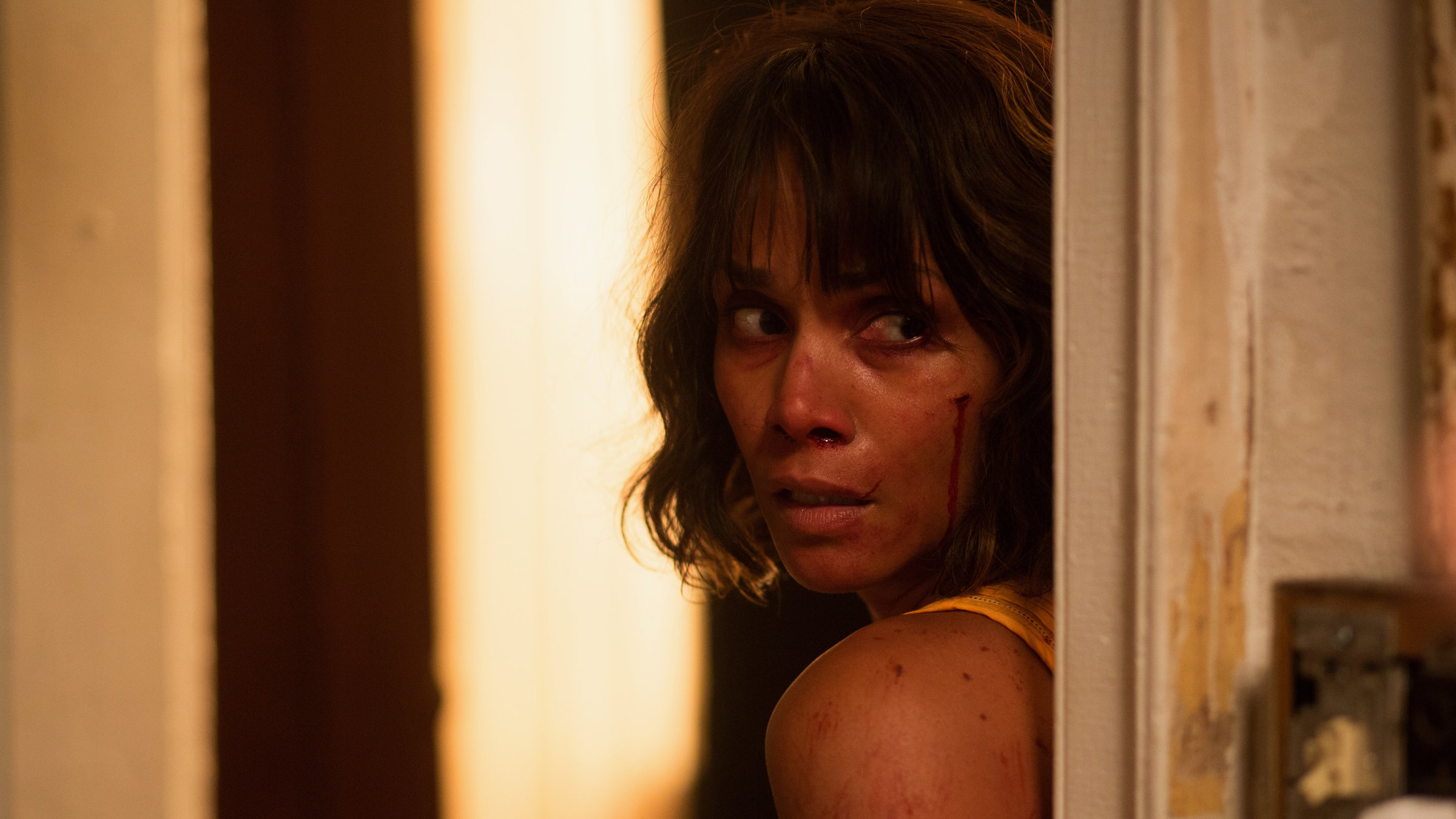 "Entführt in Louisiana": Karla Dyson (Halle Berry) lehnt sich an einen Türrahmen und hat Schrammen im Gesicht.  Sie blickt vorsichtig um die Ecke.