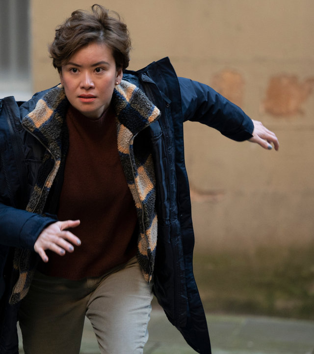 "Annika - Mord an Schottlands Küste - Enthüllungen": Blair Ferguson (Katie Leung) rennt in Sprinterhaltung durch eine Gasse, den Blick fokussiert nach vorne gerichtet.