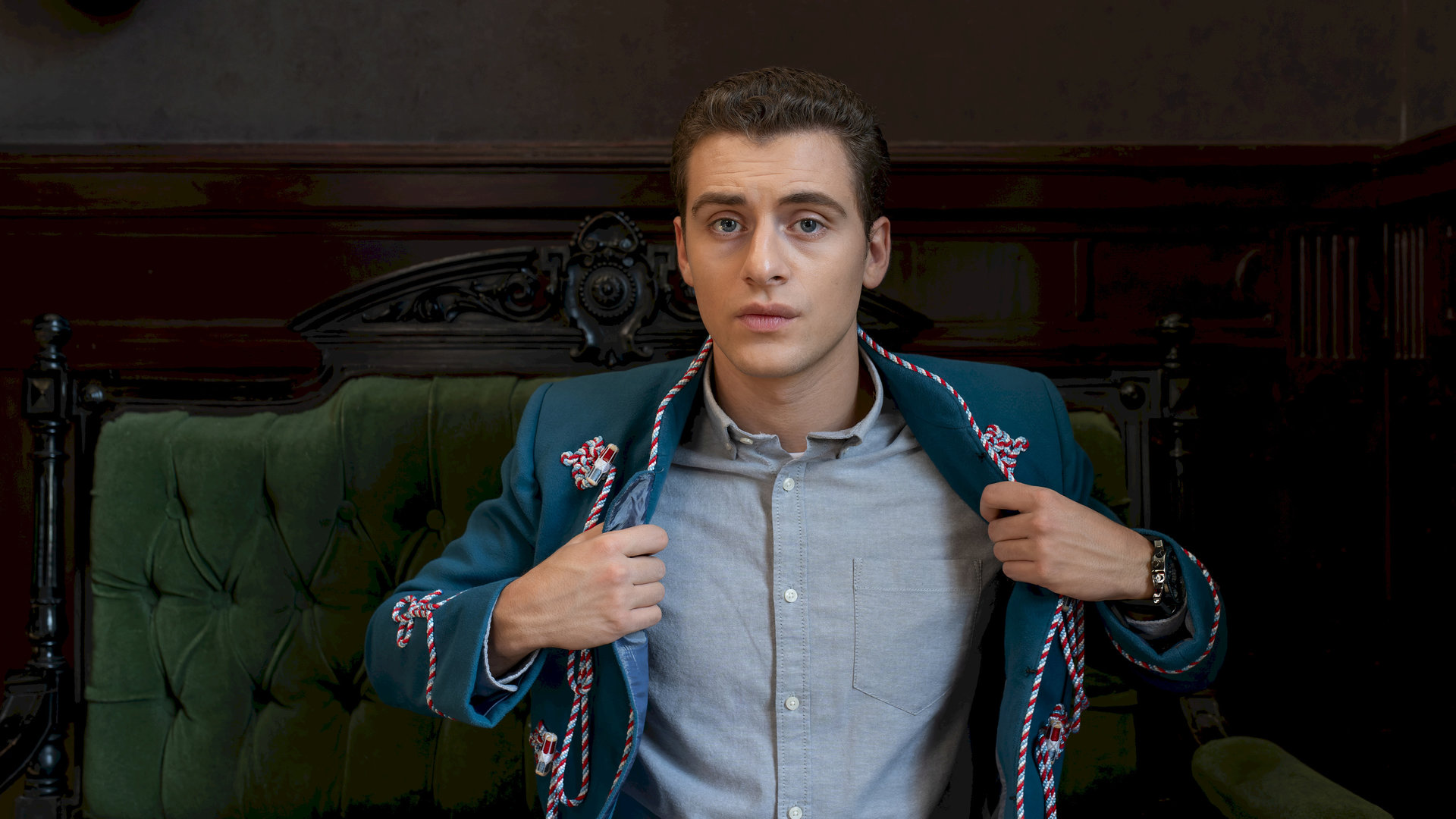 "Füxe - Der Mensch ist dem Mensch ein Wolf": Adem (Valon Krasniqi) öffnet seine Corps-Uniformjacke. Darunter trägt er ein graues Hemd.