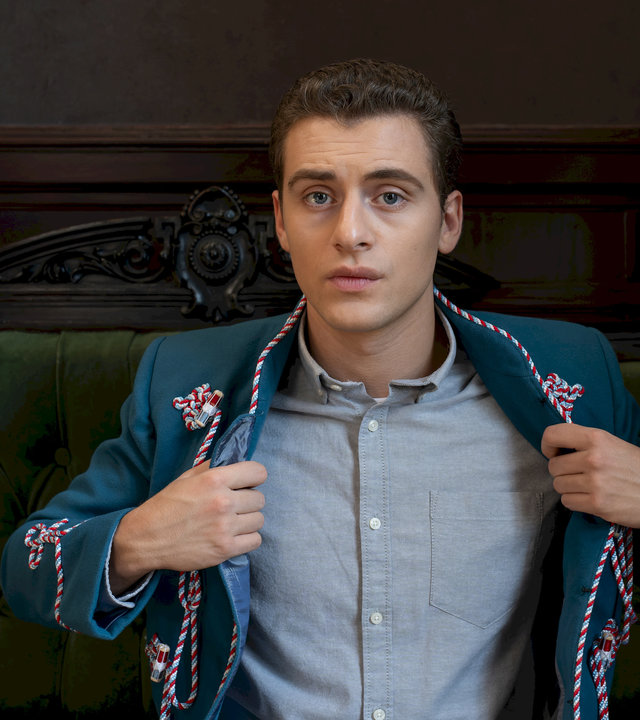 "Füxe - Der Mensch ist dem Mensch ein Wolf": Adem (Valon Krasniqi) öffnet seine Corps-Uniformjacke. Darunter trägt er ein graues Hemd.