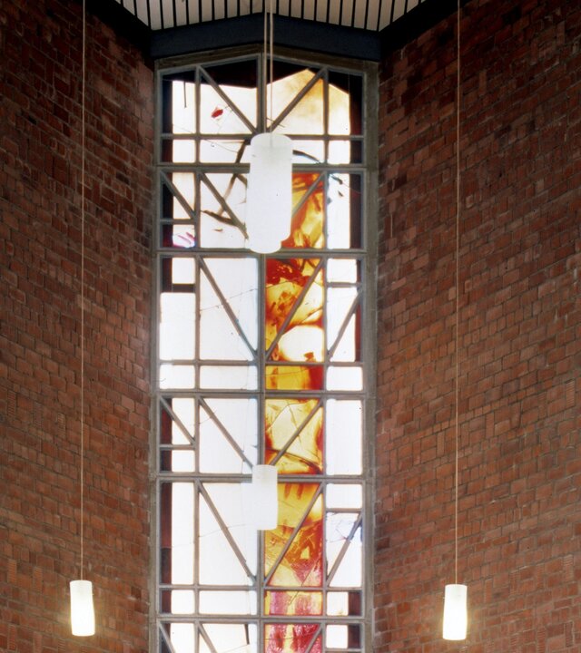 "Evangelischer Gottesdienst: UNICEF-Weltkindertag - Kinder willkommen": Teilansicht im Inneren der Christuskirche in Bad Vilbel: In dem Kirchenraum befindet sich ein hohes, helles Kirchenfenster hinter dem Altar, daneben hängen Lichter von der Decke herab und beleuchten den Raum. Im Vordergrund steht das Gestühl.