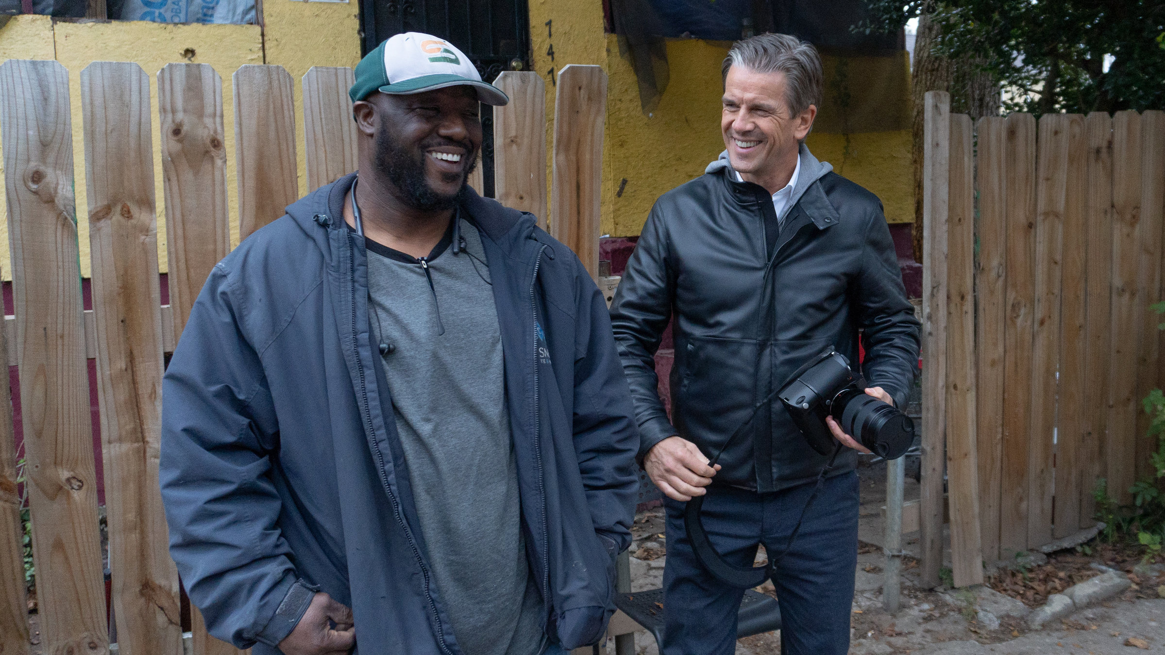 "Markus Lanz - Amerika ungeschminkt": Markus Lanz steht zusammen mit einem Automechaniker vor einem Bretterzaun. Sie lächeln sich zu.