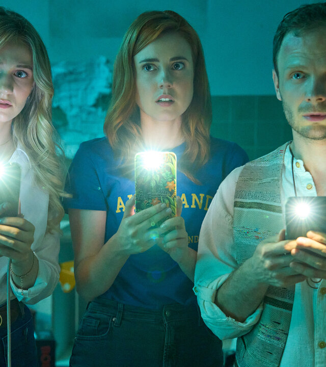 "Ich dich auch! - Der Dichtungsring": Svenja (Leonie Wesselow), Caro (Meriel Hinsching) und Hauke (Fabian Baecker) stehen im dunklen Raum nebeneinander und schauen erstaunt nach vorne. Dabei halten alle drei ihre Handys und leuchten damit nach vorne.