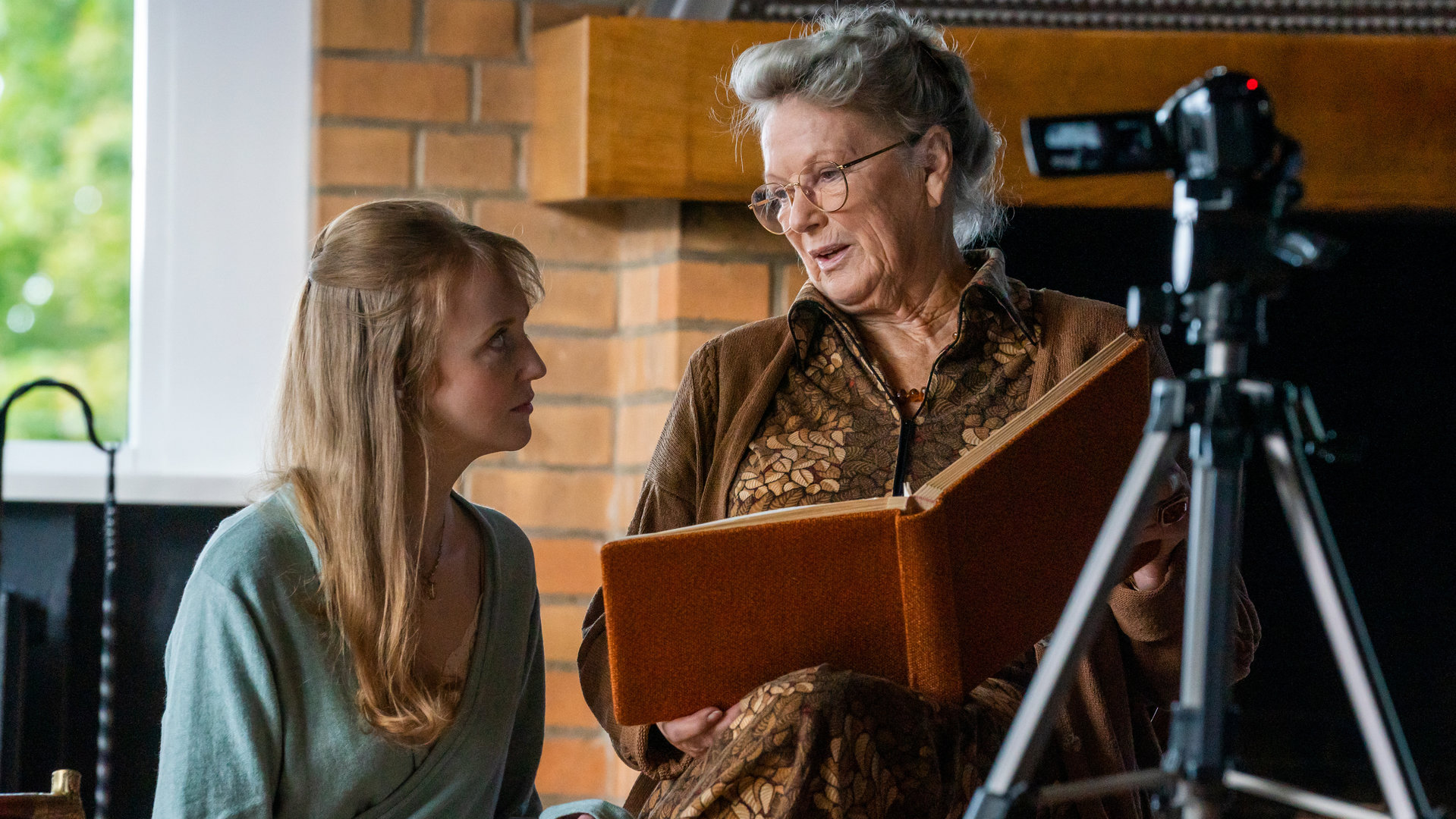 "Letzte Spur Berlin - Rosalie": Jeanette Schulz (Lilli Fichtner) und ihre Oma Rosalie Schulz (Angelika Waller) nehmen gemeinsam ein Video auf. Oma Rosalie berichtet dafür aus einem Buch, das sie in der Hand hält.