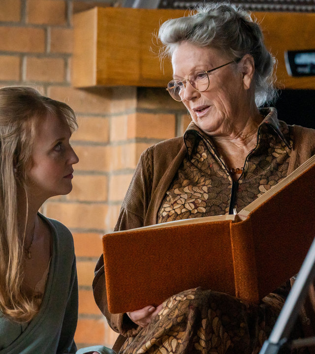 "Letzte Spur Berlin - Rosalie": Jeanette Schulz (Lilli Fichtner) und ihre Oma Rosalie Schulz (Angelika Waller) nehmen gemeinsam ein Video auf. Oma Rosalie berichtet dafür aus einem Buch, das sie in der Hand hält.