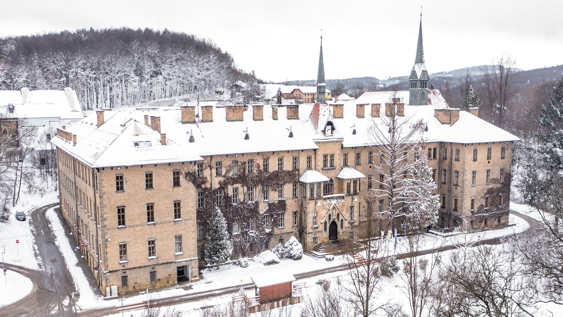 "Katholischer Gottesdienst - Jesus schenkt Licht und Wärme": Außenansicht der schneebedeckten Kirche am Schulcampus Sacré Coeur in Pressbaum.