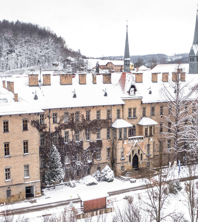 "Katholischer Gottesdienst - Jesus schenkt Licht und Wärme": Außenansicht der schneebedeckten Kirche am Schulcampus Sacré Coeur in Pressbaum.