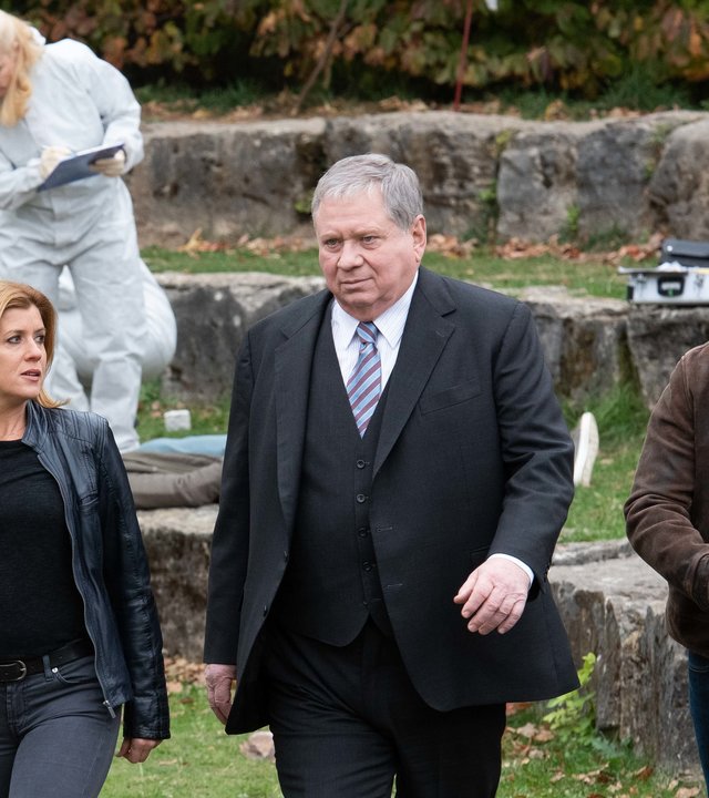 "Der Staatsanwalt - Abbrechung in Blut": Kerstin Klar (Fiona Coors), Staatsanwalt Bernd Reuther (Rainer Hunold) und Christian Schubert (Simon Eckert), der eine Drohne in der Hand hält, entfernen sich vom Tatort. Im Hintergrund sammelt Dr. Judtih Engel (Astrid Posner) im weißen Schutzanzug Beweismaterial.