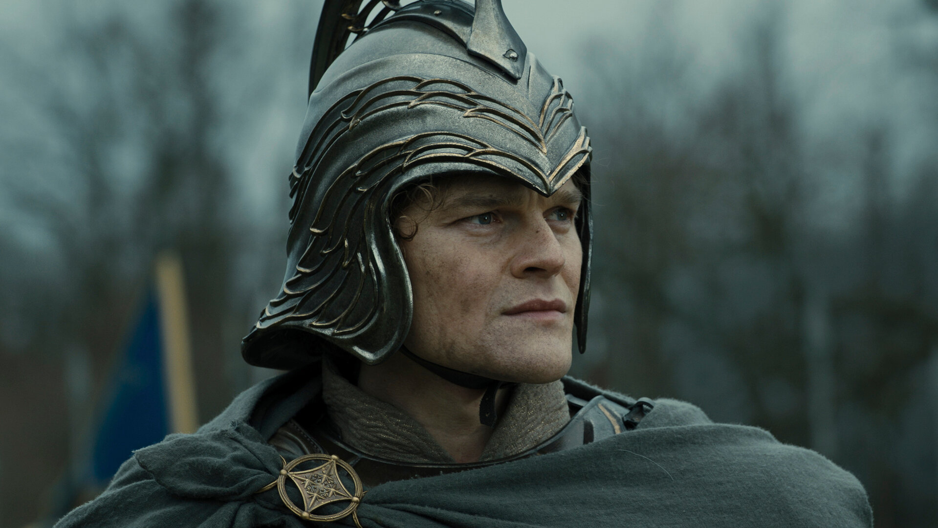 "Der Herr der Ringe: Die Ringe der Macht - Ewig dem Tode verfallen": Elrond (Robert Aramayo) steht im Freien. Er trägt einen Helm und blickt zur Seite.