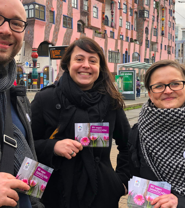"plan b: Zurück zur Freundlichkeit - Der Kampf gegen den Hass": Ein Mann und zwei Frauen stehen vor Straßenbahngleisen, im Hintergrund ein Gebäude.