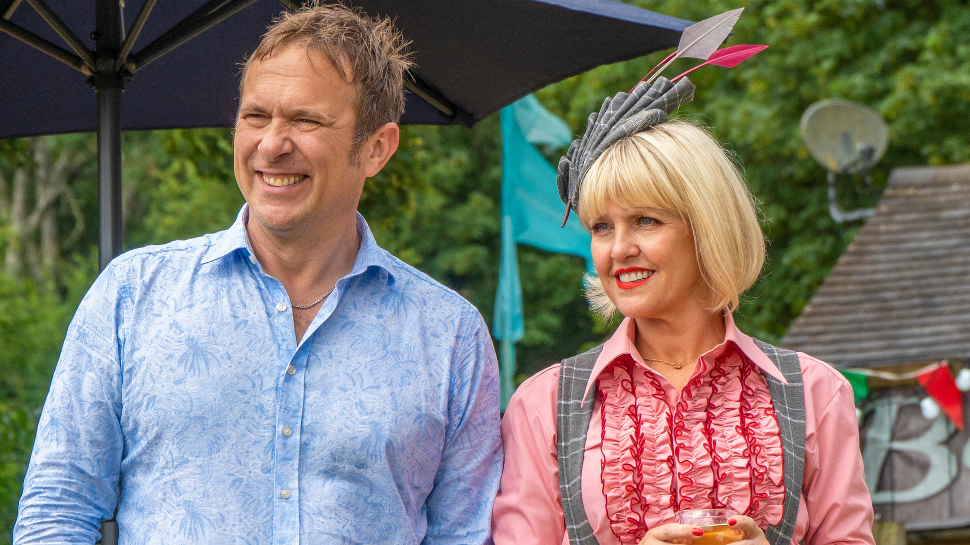 "Agatha Raisin - Und die tote Rivalin Teil 2": Agatha (Ashley Jensen) und Charles (Jason Merells) stehen nebeneinander in einem Garten und schauen gelassen in die Ferne.
