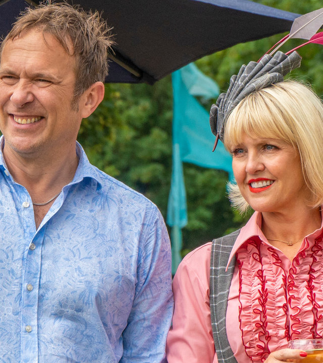 "Agatha Raisin - Und die tote Rivalin Teil 2": Agatha (Ashley Jensen) und Charles (Jason Merells) stehen nebeneinander in einem Garten und schauen gelassen in die Ferne.