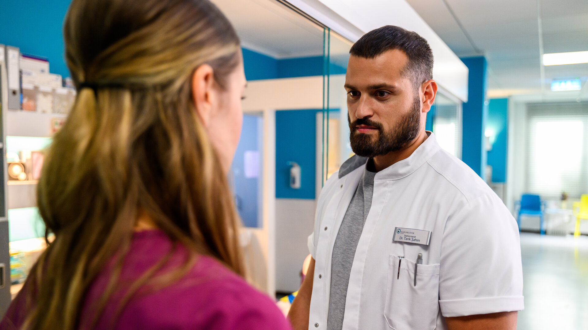 "Bettys Diagnose - Alles anders": Dr. Şahin (Nicolas Fethi Türksever) steht Betty (Henrike Hahn) im Krankenhaus gegenüber und schaut sie an.